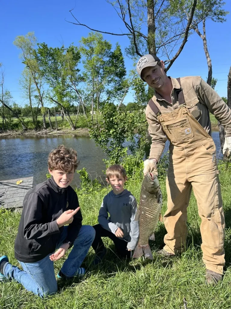 Adam with two of the kids beside the farm pond in Porter, Oklahoma.