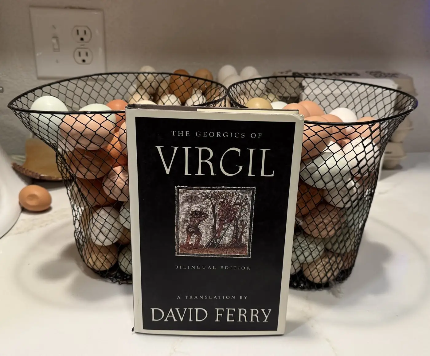 Baskets of farm fresh eggs beside a copy of Virgil's Georgics on the kitchen counter.